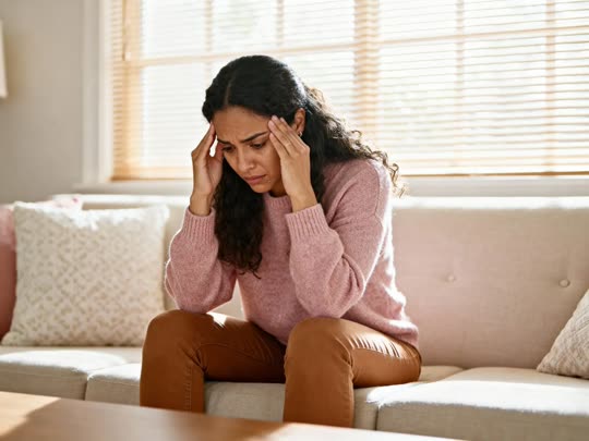 Mujer con molestia física sentada en casa.